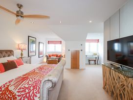 A bedroom with a bed, nightstand, and chair at Seaspell Beach House in Constantine Bay