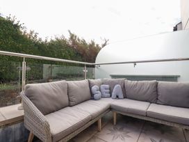 A patio area with a couch and decorative pillows at Seaspell Beach House in Constantine Bay