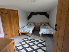 A bedroom with two single beds a bedside table a lamp and a patterned rug at Gwrtheyrn in Dyffryn Ardudwy