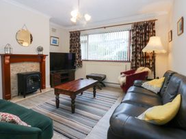 A living room with a television and fireplace at Eryl in Nefyn