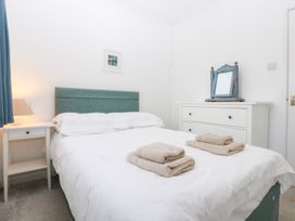 A bedroom with a bed and towels on the bed at Eryl in Nefyn