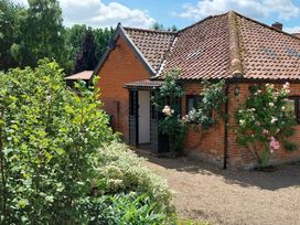 An outdoor view of a house with plants and trees at Lowbrook Cottage Dickleburgh near Diss