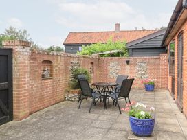 An outdoor patio with a table and chairs at Lowbrook Cottage in Dickleburgh near Diss