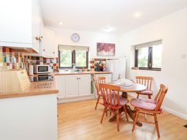 A kitchen with a table and chairs at Lowbrook Cottage in Dickleburgh near Diss