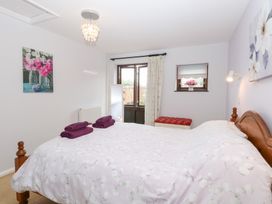 A bedroom with a bed and window at Lowbrook Cottage Dickleburgh near Diss