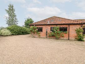 A brick building with windows and a gravel driveway at Lowbrook Cottage Dickleburgh near Diss
