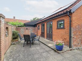 An outdoor patio area with a table and chairs at Lowbrook Cottage in Dickleburgh near Diss