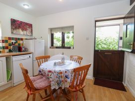 A kitchen with a table and chairs at Lowbrook Cottage in Dickleburgh near Diss