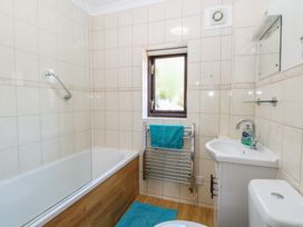 A bathroom with a bath, toilet, sink and towel rail at Lowbrook Cottage in Dickleburgh near Diss