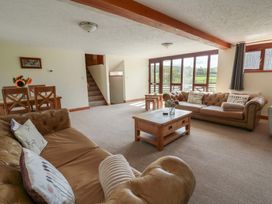 A living room with seating and a dining area at Glanyrafon St Harmon