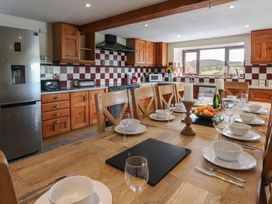 A kitchen with a dining table and appliances at Glanyrafon in St Harmon