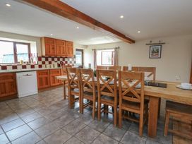 A kitchen with a dining table and chairs at Glanyrafon in St Harmon
