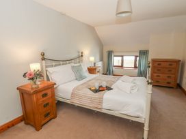 A bedroom with a bed and nightstands at Glanyrafon in St Harmon