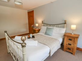 A bedroom with a bed and bedside lamp at Glanyrafon in St Harmon