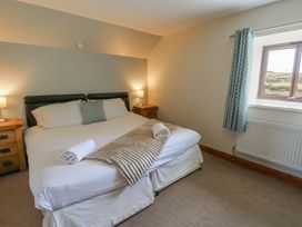 A bedroom with a bed and window at Glanyrafon in St Harmon