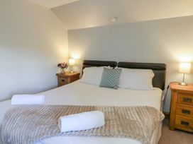 A bedroom with a bed, bedside tables and lamps at Glanyrafon in St Harmon