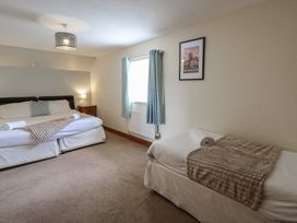 A bedroom with two beds and a nightstand at Glanyrafon in St Harmon