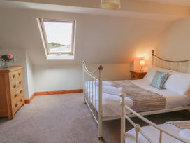 A bedroom with a bed and a dresser at Glanyrafon in St Harmon