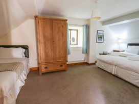 A bedroom with two beds and a wardrobe at Glanyrafon St Harmon