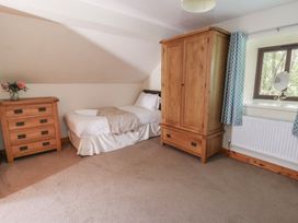 A bedroom with a bed and dresser at Glanyrafon in St Harmon