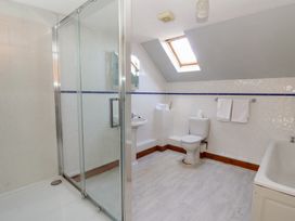 A bathroom with a shower and a bathtub at Glanyrafon St Harmon