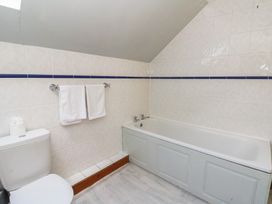 A bathroom with a bath tub and toilet at Glanyrafon St Harmon