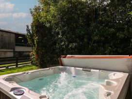 A hot tub with water in an outdoor area at Glanyrafon in St Harmon