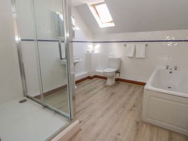 A bathroom with a shower, toilet, sink, and bathtub at Glanyrafon in St Harmon