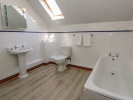 A bathroom with a bathtub, sink, and toilet at Glanyrafon in St Harmon