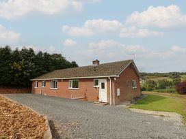 A bungalow with a driveway and garden at Glanyrafon Bungalow St Harmon