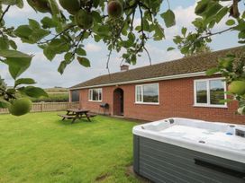 A garden with a house and hot tub at Glanyrafon Bungalow St Harmon