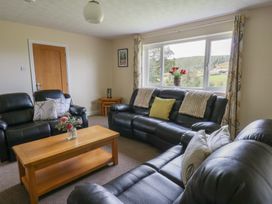 A living room with sofas and a coffee table at Glanyrafon Bungalow in St Harmon