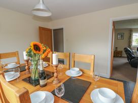A dining room with a table set for a meal at Glanyrafon Bungalow St Harmon