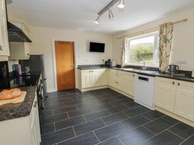 A kitchen with appliances and countertops at Glanyrafon Bungalow St Harmon