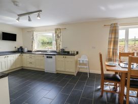 A kitchen with a dining table and chairs at Glanyrafon Bungalow in St Harmon
