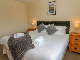 A bedroom with a bed and bedside tables at Glanyrafon Bungalow in St Harmon