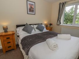 A bedroom with a large bed and bedside tables at Glanyrafon Bungalow in St Harmon