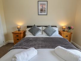A bedroom with a bed and bedside tables at Glanyrafon Bungalow St Harmon
