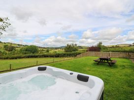 An outdoor area with a hot tub and picnic table at Glanyrafon Bungalow St Harmon