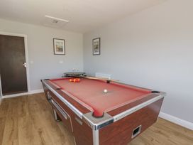 A games room with a pool table and cue sticks at Glanyrafon Bungalow in St Harmon