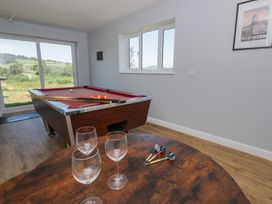 A snug with a pool table and wine glasses at Glanyrafon Bungalow in St Harmon