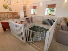 A living room with a staircase and seating area at Silvermine House in Charlestown
