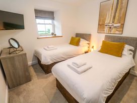 A bedroom with two beds, a television, and a window at Silvermine House in Charlestown
