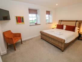 A bedroom with a bed and armchair at Silvermine House Charlestown