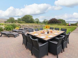 An outdoor dining area with a large table and chairs at Silvermine House Charlestown
