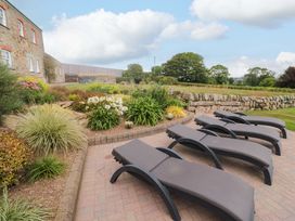 A garden area with sun loungers and flower beds at Silvermine House in Charlestown