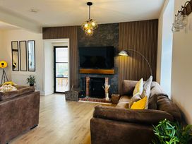 A living room with a sofa and television at Trearddur View in Treaddur Bay