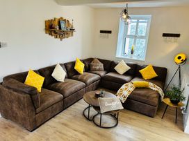A living room with a sofa and a coffee table at Trearddur View in Treaddur Bay