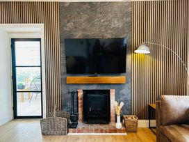 A living room with a television and a fireplace at Trearddur View in Treaddur Bay