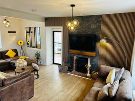 A living room with a sofa and television at Trearddur View in Treaddur Bay
